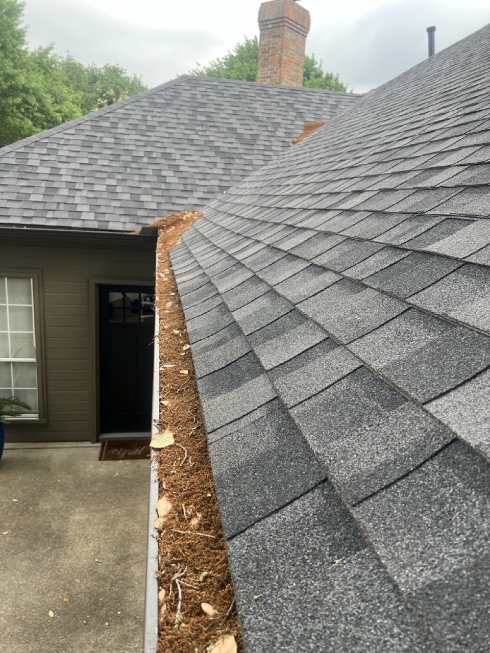 Gutter packed with leaves and dirt before professional gutter cleaning